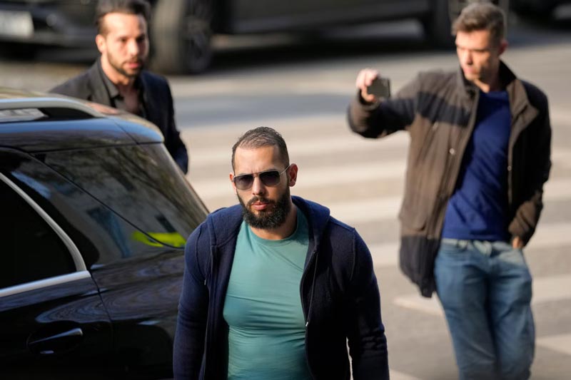 Andrew Tate (front) and his brother Tristan (behind, left) arrive outside the Directorate for Investigating Organized Crime and Terrorism (DIICOT) earlier this month